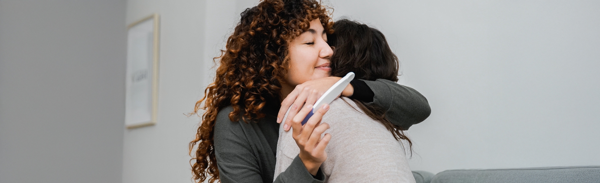 Happy couple embracing with positive pregnancy test, donor eggs and surrogacy support, Dr Kate Burston Newcastle