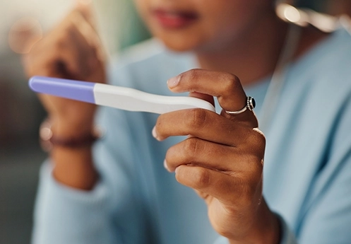 Woman holding pregnancy test – fertility care Newcastle